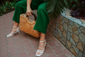 ženska v belih sandalih in zelenem kombinezonu