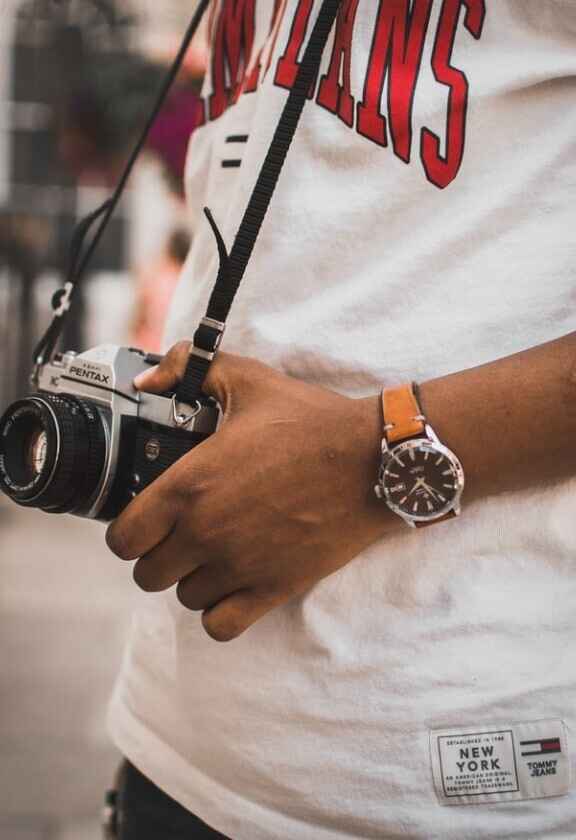 moški fotograf v beli majici tommy hilfiger